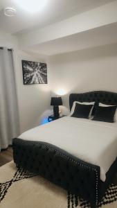 a bedroom with a large bed with a black headboard at Hebzibah's Luxe in Prince George