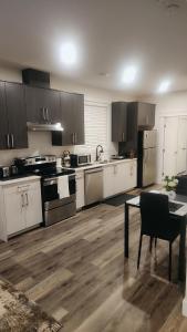a kitchen with white cabinets and a table in it at Hebzibah's Luxe in Prince George