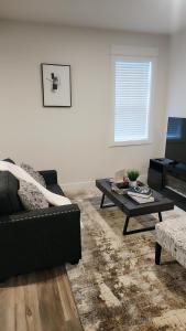 a living room with a couch and a coffee table at Hebzibah's Luxe in Prince George