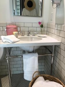 a white bathroom with a sink and a mirror at Hollywood Hotel in Los Angeles