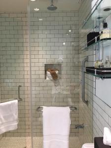 a bathroom with a glass shower with white towels at Hollywood Hotel in Los Angeles