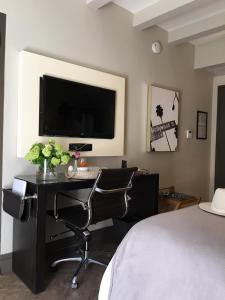 a bedroom with a desk with a television and two chairs at Hollywood Hotel in Los Angeles
