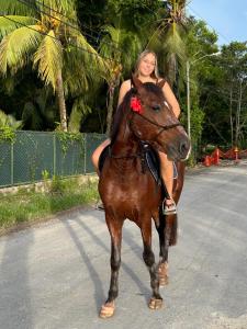 a woman is riding a horse on the road at Blue Marlin in Bocas Town