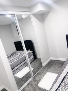 a bedroom with a mirror and a bed in it at ClassicPavillion INN in Bowmanville