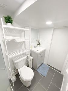 a white bathroom with a toilet and a sink at ClassicPavillion INN in Bowmanville +47 photos