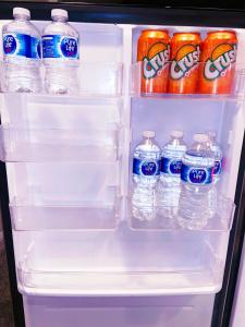 an open refrigerator filled with bottles of water and soda at ClassicPavillion INN in Bowmanville