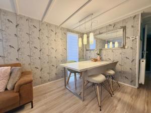 a dining room with a table and a couch at Ermway Cottage in Erm +9 photos