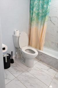 a bathroom with a toilet with a shower curtain at Modern 2BR Basement Suite Private Entrance in Brampton