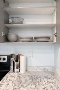 a kitchen counter with plates and bowls on a shelf at Modern 2BR Basement Suite Private Entrance in Brampton +2 photos