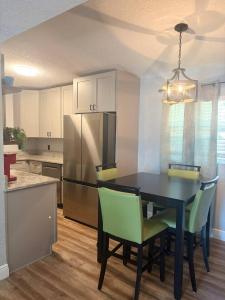 a kitchen with a black table with chairs and a refrigerator at Amelia’s Arena Retreat in Orlando +66 photos