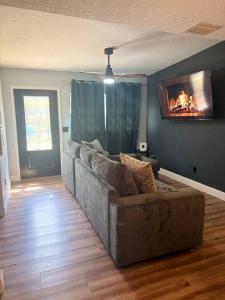 a living room with a couch and a tv on the wall at Amelia’s Arena Retreat in Orlando