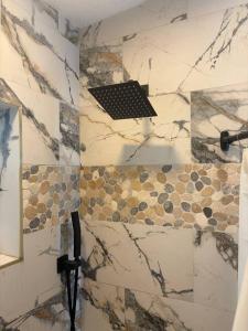 a bathroom with a shower with a stone wall at Amelia’s Arena Retreat in Orlando