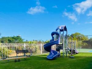 a playground with a blue slide on the grass at NaboBlue Ocean View Apartment Maunabo PR in Maunabo