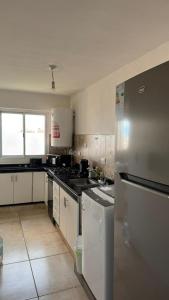 a kitchen with white cabinets and a stainless steel refrigerator at Departamento Céntrico Equipado in San Fernando del Valle de Catamarca