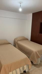 a room with two beds and a dresser in a room at Departamento Céntrico Equipado in San Fernando del Valle de Catamarca