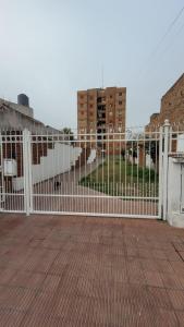 a white fence in front of a building at Departamento Céntrico Equipado in San Fernando del Valle de Catamarca