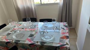 a table with glasses and plates on top of it at Departamento Céntrico Equipado in San Fernando del Valle de Catamarca +2 photos