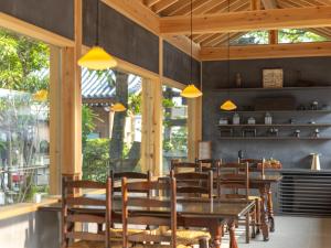 a dining room with wooden tables and chairs at 宿坊 観音院 Temple Hotel Kannonin in Kiryu
