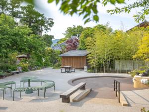 a park with benches and tables and a building at 宿坊 観音院 Temple Hotel Kannonin in Kiryu