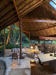 a pavilion with a woman sitting on a couch at Dalakit House Hidden Garden Oasis in Lambojon