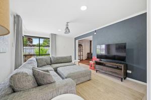 a living room with a couch and a flat screen tv at Dixon Delight in Inverloch