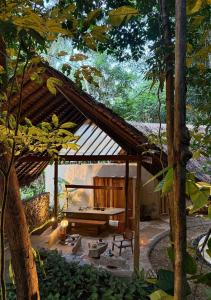 a pavilion with a picnic table in a garden at Dalakit House Hidden Garden Oasis in Lambojon +7 photos