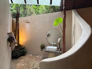 a bathroom with a sink and a mirror on a wall at Dalakit House Hidden Garden Oasis in Lambojon