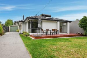 a house with a deck with a table and chairs at Dixon Delight in Inverloch