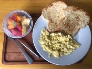a plate of food with toast and a bowl of vegetables at Naomi Homestay in Padangbai
