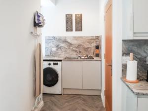 a kitchen with a washing machine and a washer and dryer at Invergyle - Uk40566 in Falkland