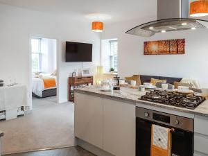 a kitchen with a stove top oven next to a living room at Invergyle - Uk40566 in Falkland