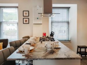 a kitchen with a long table with tea sets on it at Invergyle - Uk40566 in Falkland