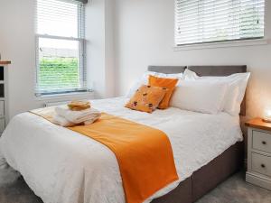 a bedroom with a bed with an orange blanket at Invergyle - Uk40566 in Falkland +12 photos