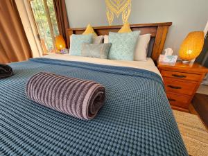 a bedroom with a bed with a blanket on it at Cosy Studio with Forest Views, Noosa Hinterland in Doonan