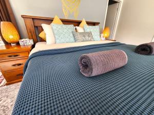 a large bed with a blue and white comforter at Cosy Studio with Forest Views, Noosa Hinterland in Doonan +45 photos