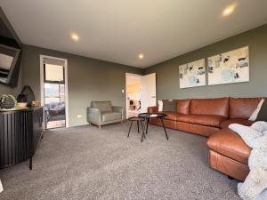 a living room with a couch and a chair at Style, Space and Comfort in Twizel
