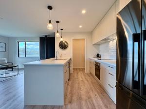 a kitchen with white cabinets and a white counter top at Style, Space and Comfort in Twizel
