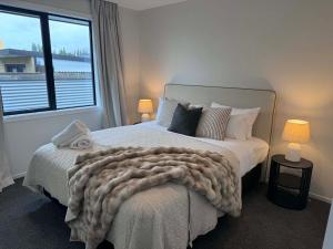 a bedroom with a large bed with a large window at Style, Space and Comfort in Twizel