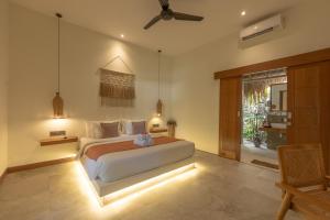 ein Schlafzimmer mit einem großen Bett mit Beleuchtung in der Unterkunft Reset Lombok Hotel in Kuta Lombok + 36 Fotos