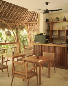 ein Esszimmer mit zwei Holztischen und Stühlen in der Unterkunft Reset Lombok Hotel in Kuta Lombok