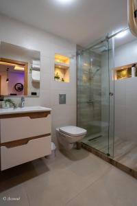 a bathroom with a toilet and a glass shower at RamoHouse bright home central in Chefchaouen +33 photos