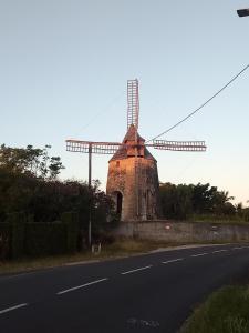 a windmill sitting on the side of a road at Chambre d'hôtes du Moulin SPA in Sainte-Anne