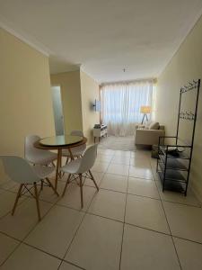 a living room with a table and chairs and a couch at Lar doce lar! in Divinópolis
