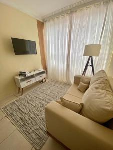 a living room with a couch and a flat screen tv at Lar doce lar! in Divinópolis