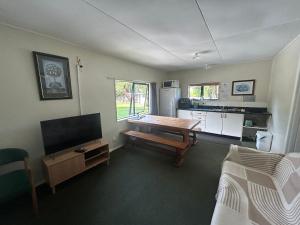 a living room with a table and a tv in it at Kiwi Park Motels in Murchison