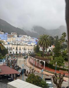 a city with buildings and palm trees and a mountain at RamoHouse bright home central in Chefchaouen