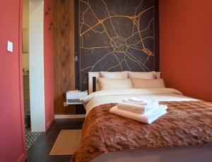 a bedroom with a bed with a spider painting on the wall at L'Escapade Tournaisienne in Tournai
