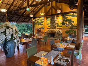 a restaurant with tables and chairs and a fireplace at THANYAWANA Glamping Tents in Khao Sok National Park