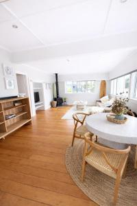 a living room with a table and a couch at Lukes Kitchen Bach in Kuaotunu