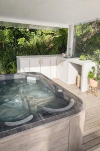 a jacuzzi tub in the middle of a room at Lukes Kitchen Bach in Kuaotunu +5 photos